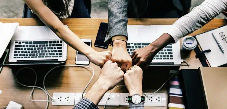 Group collaborating with hands together.